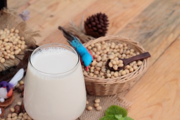 Soy milk and soybeans on wood background.