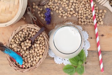 Soy milk and soybeans on wood background.