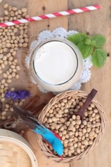 Soy milk and soybeans on wood background.