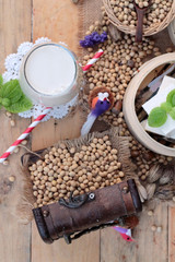 Soy milk and soybeans on wood background.