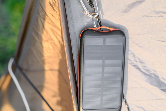 Portable solar panel for charging mobile devices hanging on the tent