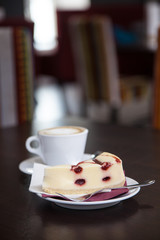 Cheesecake and coffee mug on a wooden table in restaurant