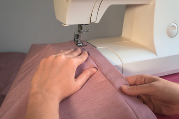 Seamstresses hands working on sewing machine