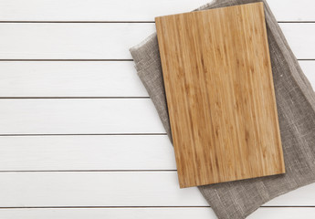 Cutting board and napkin on the wooden background. Top view.