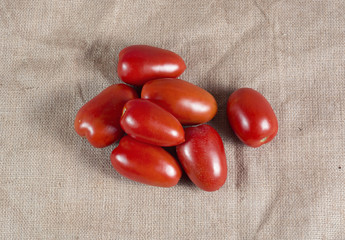 Ripe red tomatoes on a burlap canvas