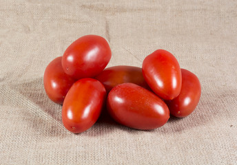Ripe red tomatoes on a burlap canvas