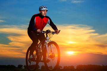 Fototapeta na wymiar young adult cyclist riding mountain bike in the countryside
