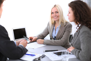 Fototapeta premium A group of business people at a meeting on the background of office. Focus on a beautiful blonde