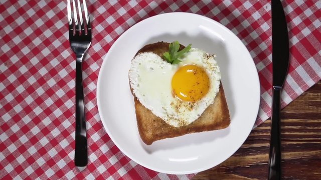 Heart-shaped fried eggs for breakfast. dolly shot