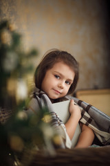 Fototapeta na wymiar little cute girl sitting near christmas tree and reading book