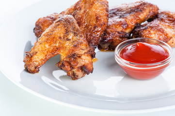 Crispy fried chicken wings with ketchup on a white background