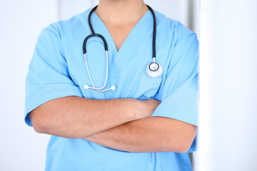 Portrait of unknown male surgeon doctor standing near the wall  in hospital office