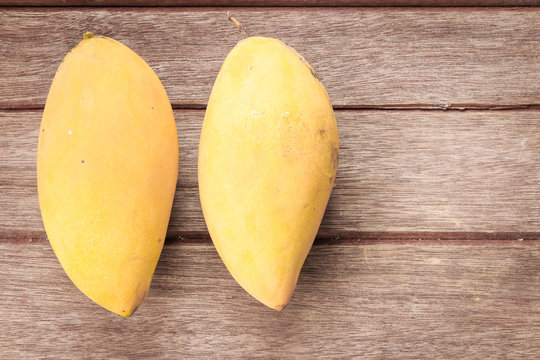Yellow Mangoes on wooden background