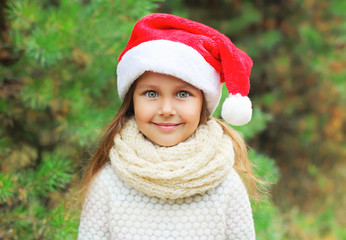 Christmas and people concept - portrait little girl child in san