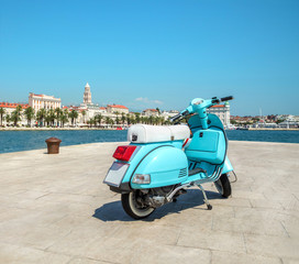 Naklejka premium Blue vintage scooter on the waterfront