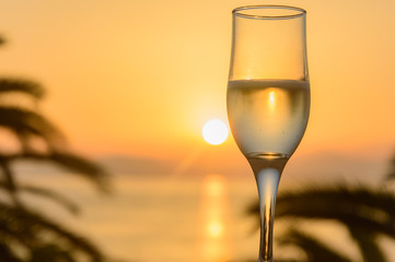 Glass of wine at sunrise at sea