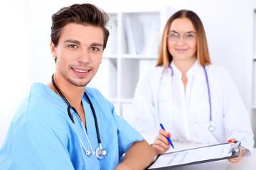 Fototapeta premium Attractive male doctor near female doctor