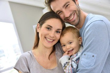 Obraz premium Portrait of happy parents holding baby girl