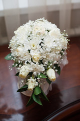 Bride holding wedding bouquet with white roses and other flowers