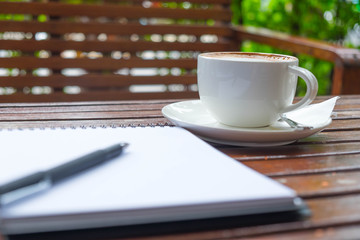 Coffee of cup and pen put on notepad