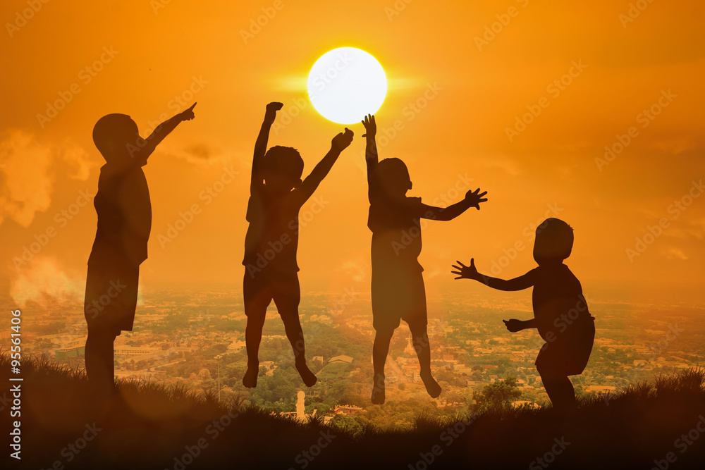 Wall mural silhouette of boy happy jumping touch  the sun , sunset backgrou