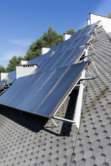 Hot water solar heating system - Solar panels on the roof - green energy, renevable energy, alternative energy - vertical image - nobody
