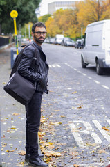 Modello uomo con barba in contesto urbano vestito di nero