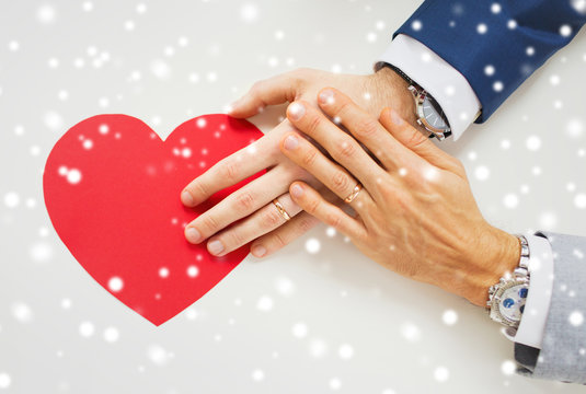 Close Up Of Male Gay Couple Hands With Red Heart