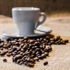 Kaffeetasse mit Kaffeebohnen auf Jute