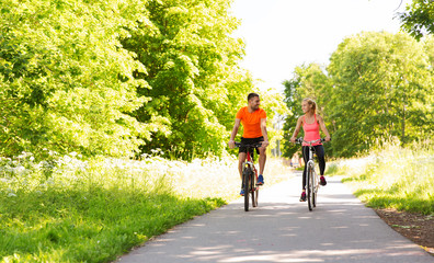 happy couple riding bicycle outdoors