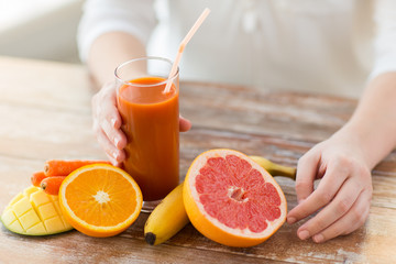 close up of woman hands with juice and fruits