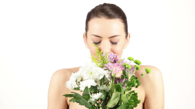 Young woman smelling a fresh bouquet of flowers and sneezing