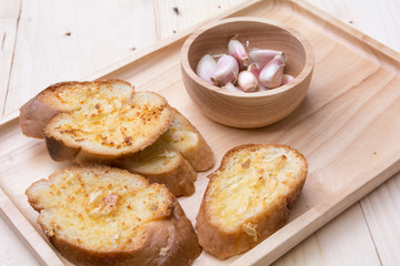 crispy garlic bread in wood tray