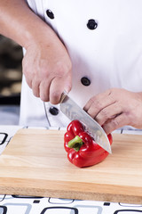 Chef cutting red bell pepper