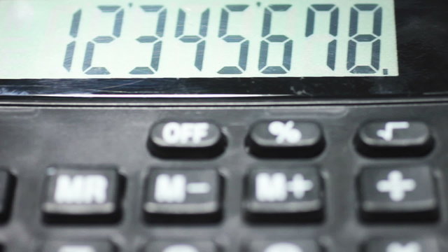 Panning over a cropped calculator displaying the keys and screen with numbers on