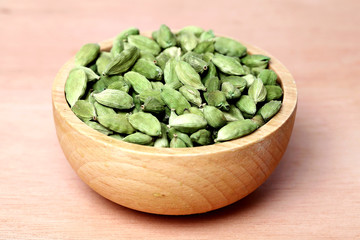 Cardamom pods in a wooden bowl