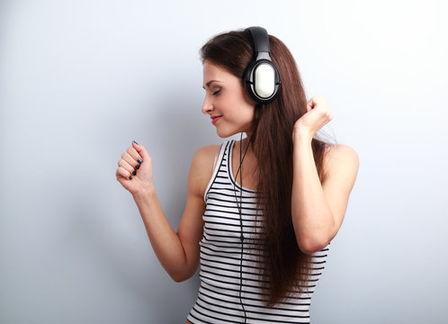 Young beautiful woman listening the music from modern headphones