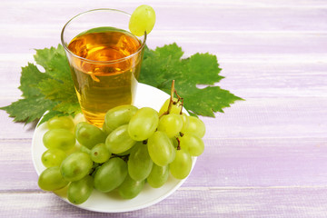 Glass of grape juice on wooden background