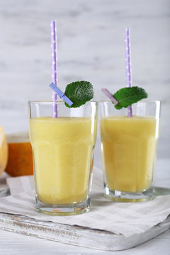 Glasses of melon cocktail on white wooden background