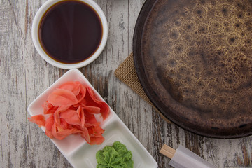 Top view of empty plate and sushi chopsticks on old wooden table.