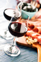 Red wine with charcuterie assortment on the background