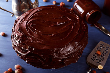 delicious cake with liquid chocolate glaze on blue wooden table