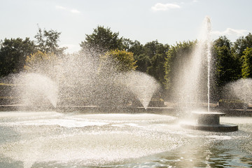 Decorative fountain display creating water sprays in a pond.