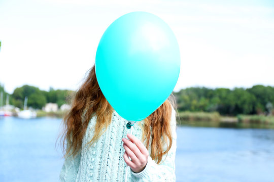 Girl Holding Balloon Near Face