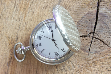 Silver pocket watch on wooden background