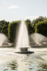 Naklejka premium Decorative fountain display creating water sprays in a pond.