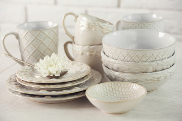 Clean dishes on table on brick wall background
