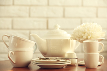 Clean dishes on table on brick wall background
