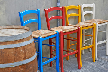 Fototapeta na wymiar Colored chairs in street cafe