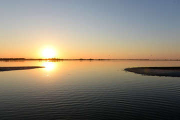 Fototapeta na wymiar Golden sunrise over calm water